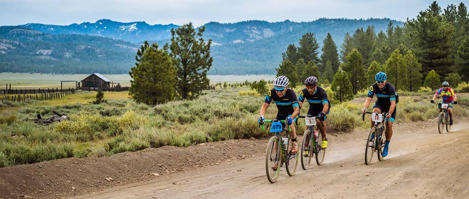 Riders in a mountain valley with an old barn in the background